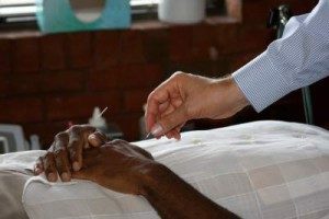 Dr. Mitchell places needles in the hands of a patient to resolve his pain.