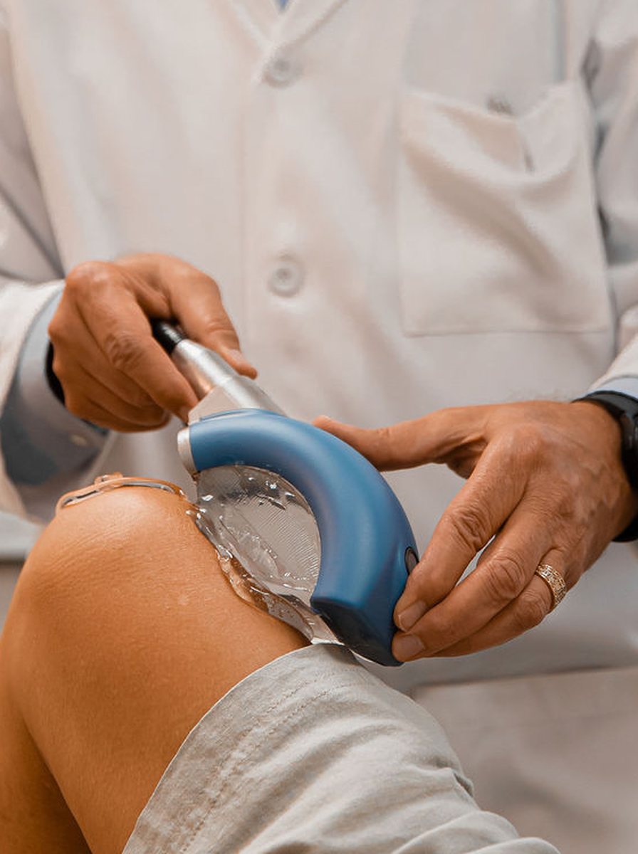 Dr. Thomas Mitchell, DC, applying Piezowave acoustic-wave therapy to a patient’s knee