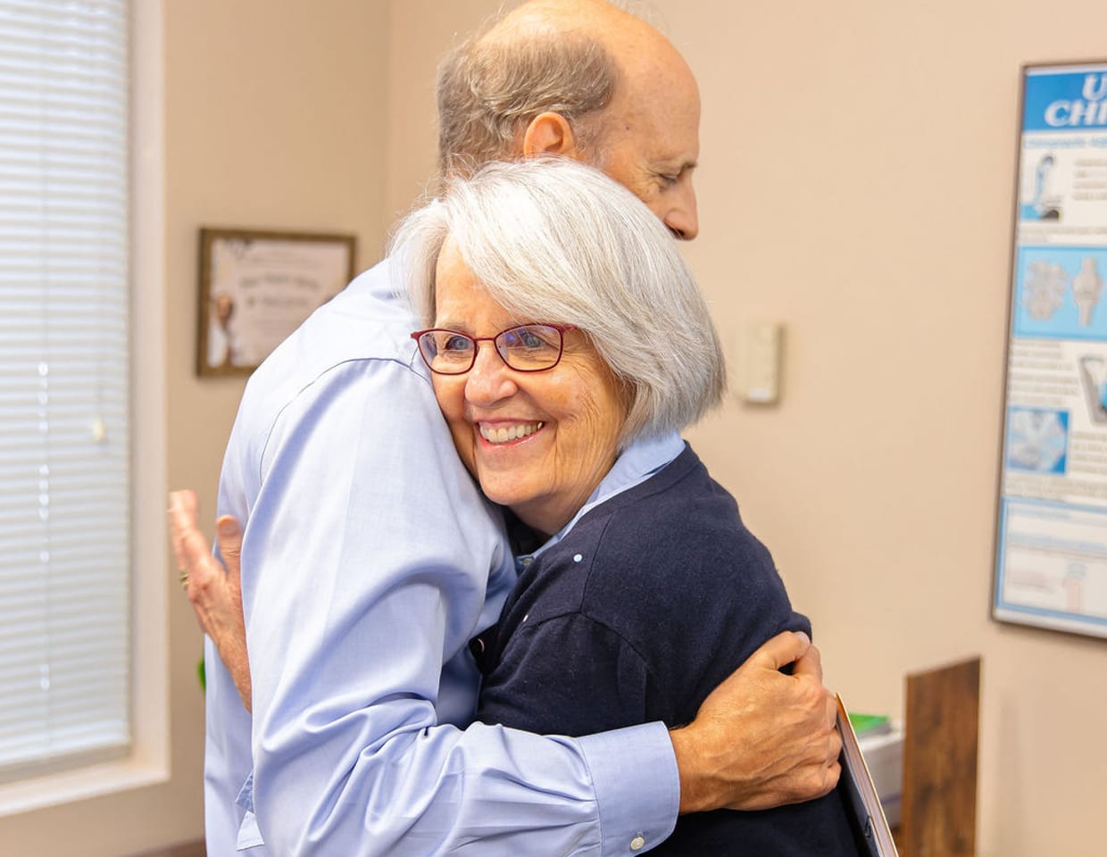 A patient embracing Dr. Thomas Mitchell, DC, after care